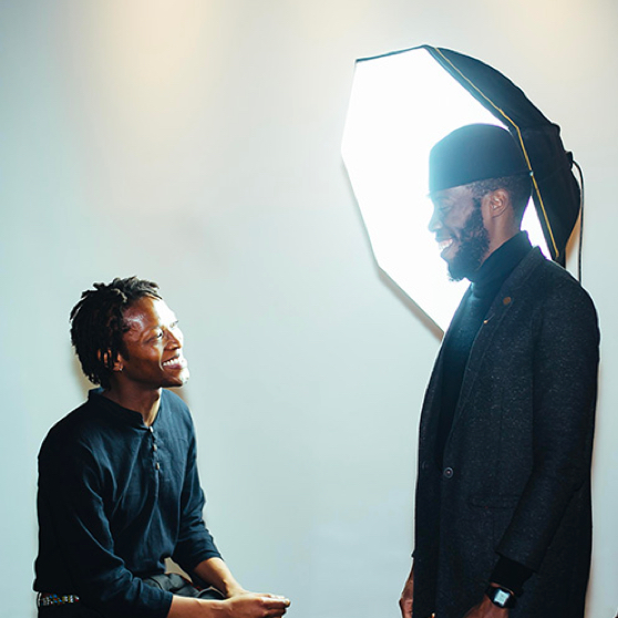 two men standing by a photography light